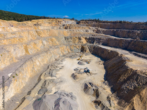 Foto Large quarry with multiple levels cut into the hillside shows machinery and pile