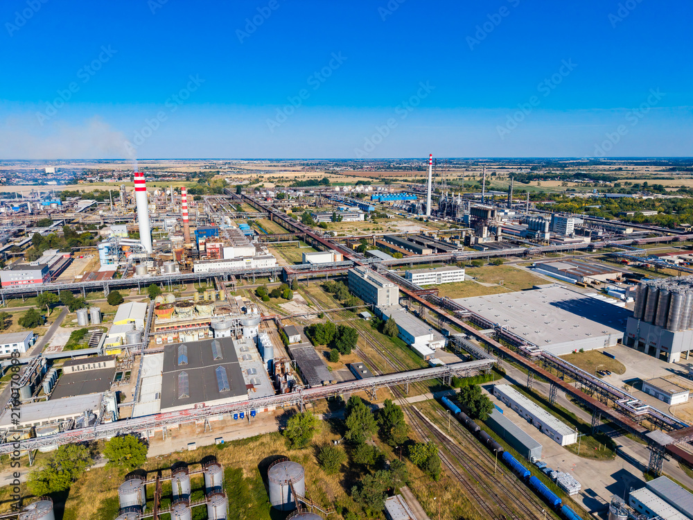 Fototapeta premium Industrial area with factories and equipment near a clear sky and green fields during the day