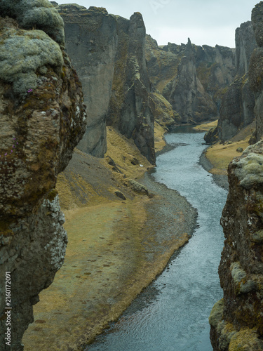 Winding river through dramatic moss-covered canyon in Iceland