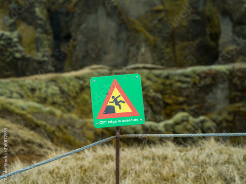 Cliff edge warning sign in rugged Icelandic landscape