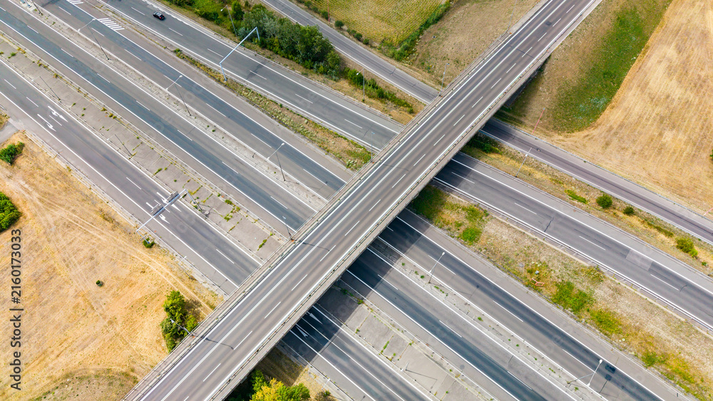 Fototapeta premium A view of a highway interchange with multiple roads crossing at a rural location during daylight