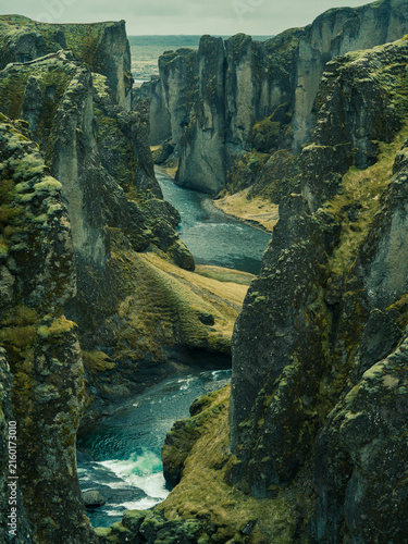 Winding river through dramatic moss-covered canyon in Iceland