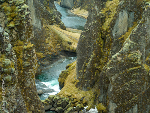 Winding river through dramatic moss-covered canyon in Iceland