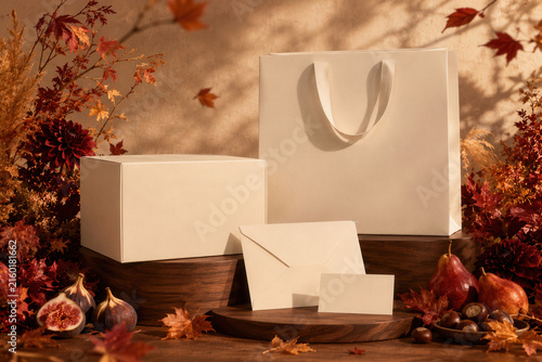 Soft autumn leaves drift around crisp white gift boxes