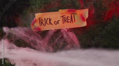 Trick or Treat sign with gummy worms in red glowing fog