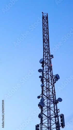 Cuadro en lienzo Tall telecommunications tower with microwave dish antennas against a clear blue