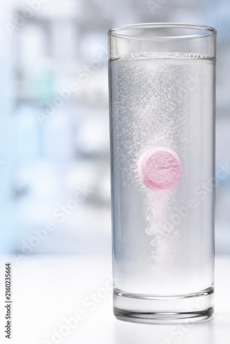 Burbujas de una pastilla efervescente disolviéndose en un vaso con agua clara