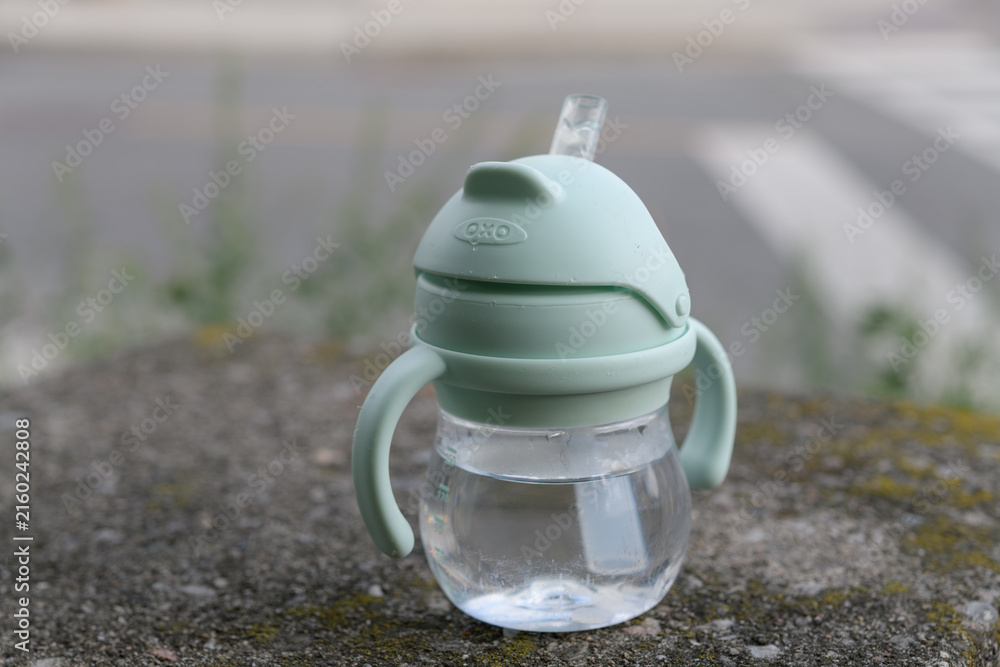 Naklejka premium lost OXO Tot Transitions Straw Cup with Handles on an old concrete wall in Toronto's Rosedale