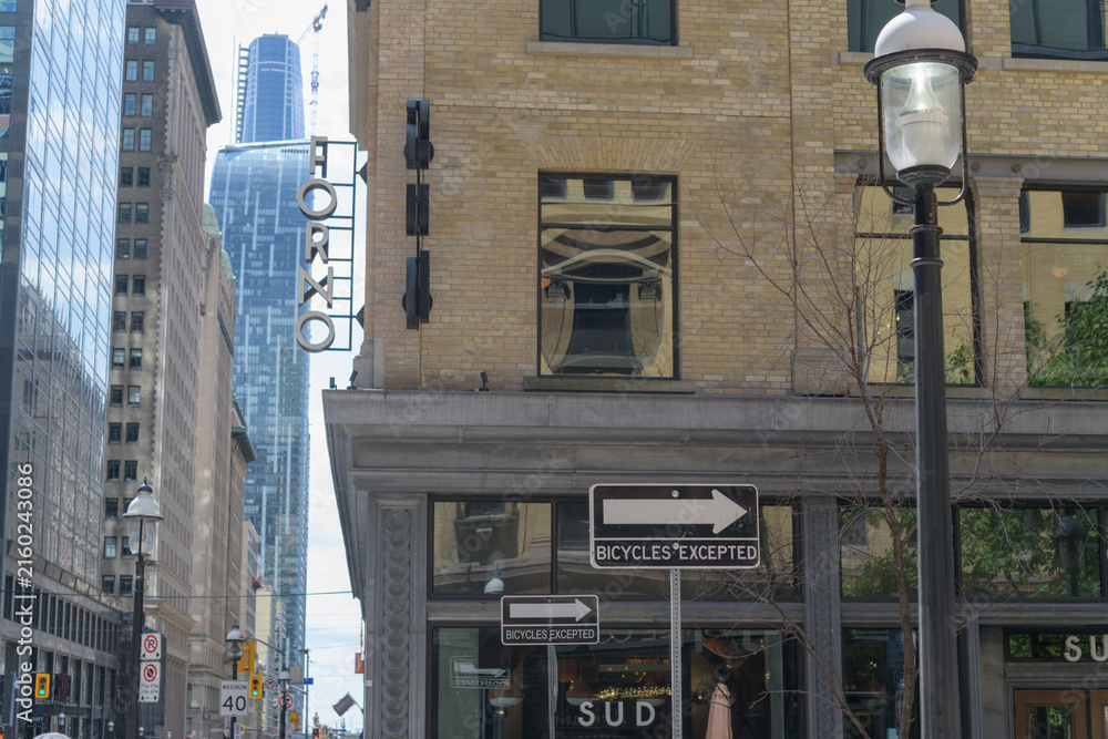 Fototapeta premium one way (bicycles excepted) traffic sign and defocused view, exterior historic building and signage at Sud Forno, a restaurant, located at 132 Yonge St, Toronto
