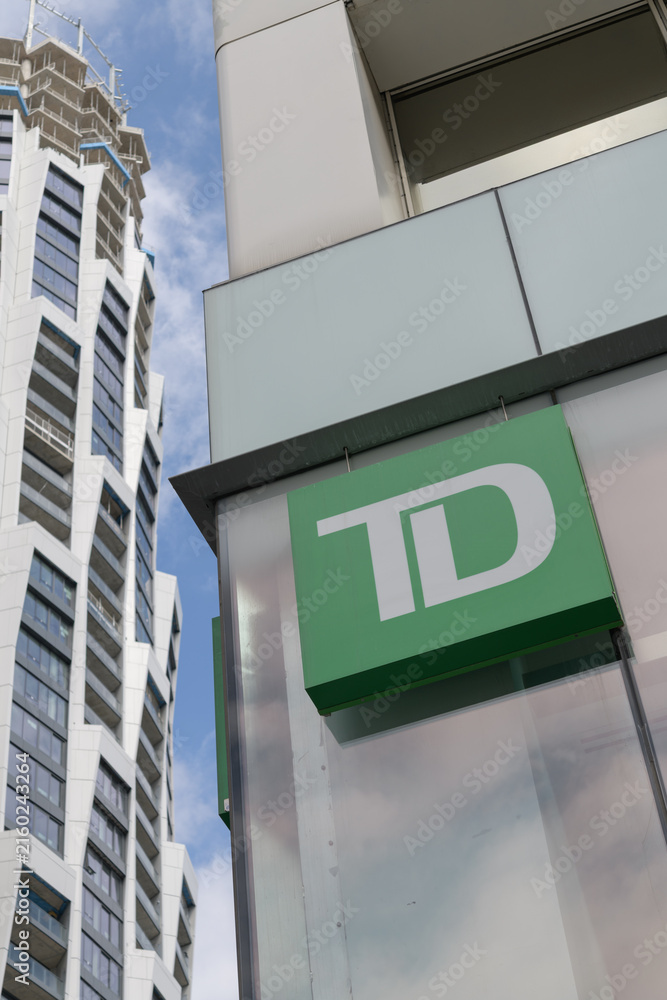 Fototapeta premium TD corporate logo sign outside branch at 2 St Clair Av E with view of One Delisle condo tower, Toronto