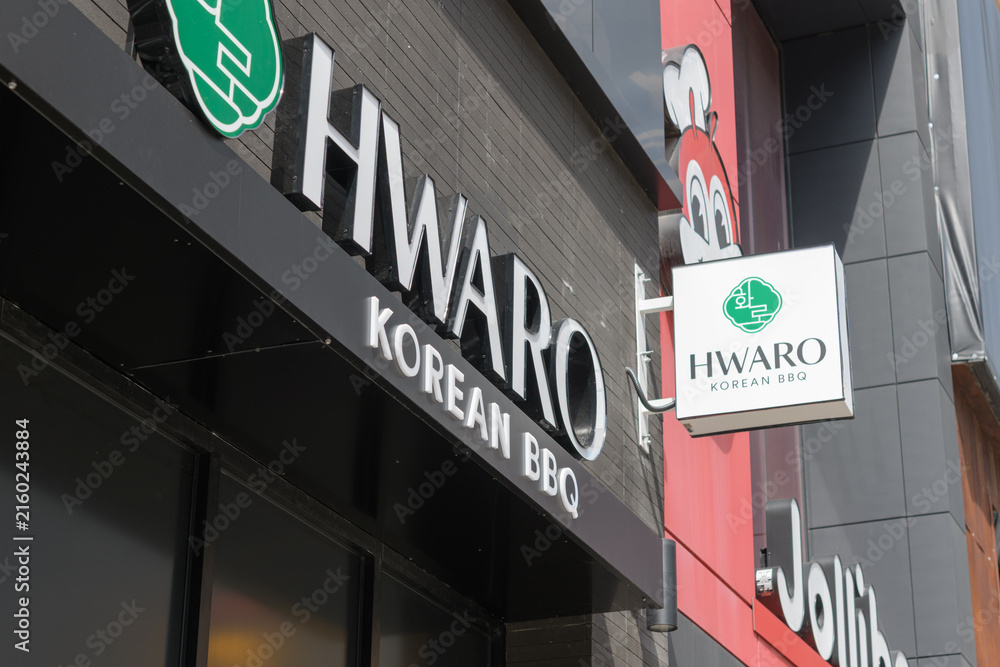 Fototapeta premium Hwaro Korean BBQ (332 Yonge St) and Jollibee chicken restaurant (334 Yonge St) signs in Toronto