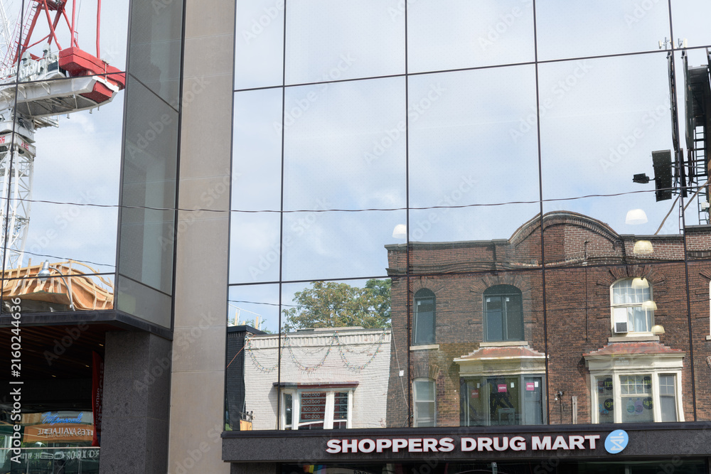 Fototapeta premium exterior building facade composed of mirror glass panes and sign of Shoppers Drug Mart, a pharmacy chain, located here at 1027 Yonge St, Toronto