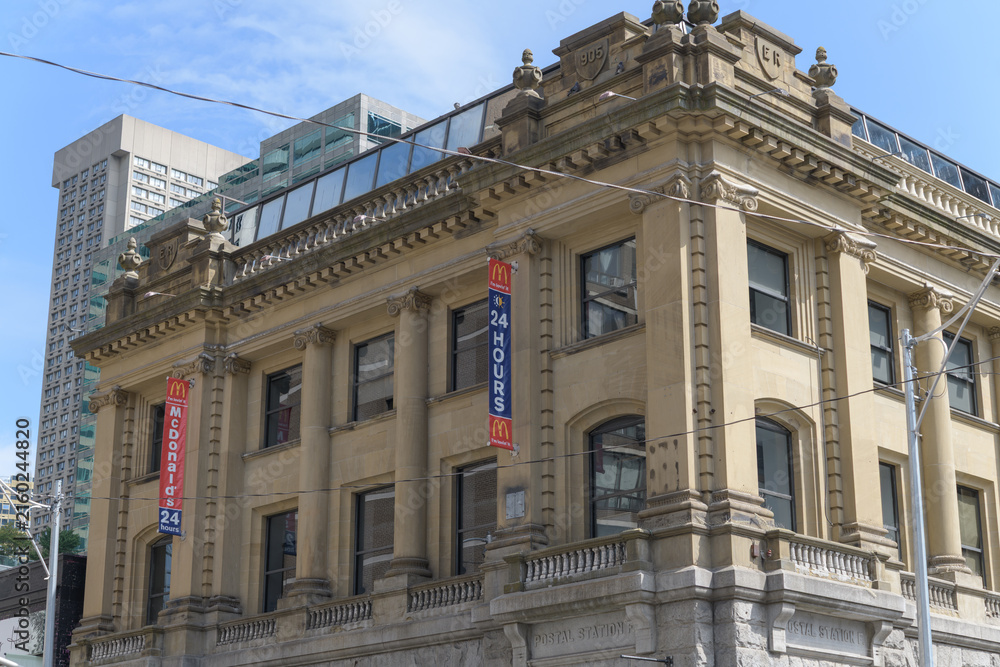 Fototapeta premium exterior building facades and banners of McDonald's Canada fast food restaurant located at 675 Yonge St, Toronto (Postal Station F, designed by SG Curry, 1905)