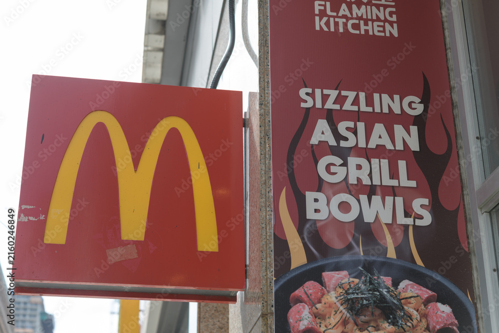 Naklejka premium two projecting signs on the exterior of McDonald's Canada fast food restaurant (470 Yonge St) and Flaming Kitchen (472 Yonge St), Toronto