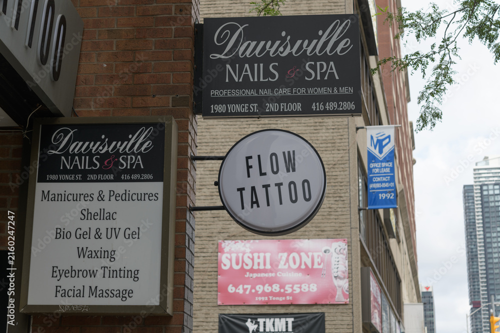 Fototapeta premium signage around Flow Tattoo located at 1980 Yonge St, Toronto (Sushi Zone, Davisville Nails & Spa)