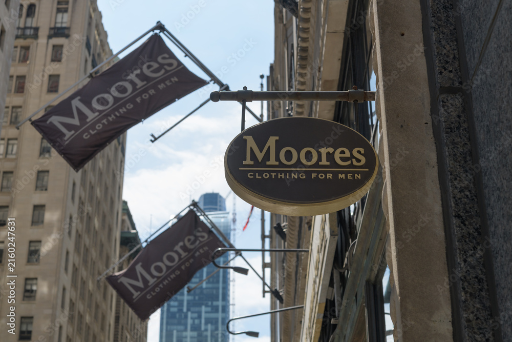 Fototapeta premium signs and flags outside Moores Clothing for Men located at 100 Yonge St, Toronto