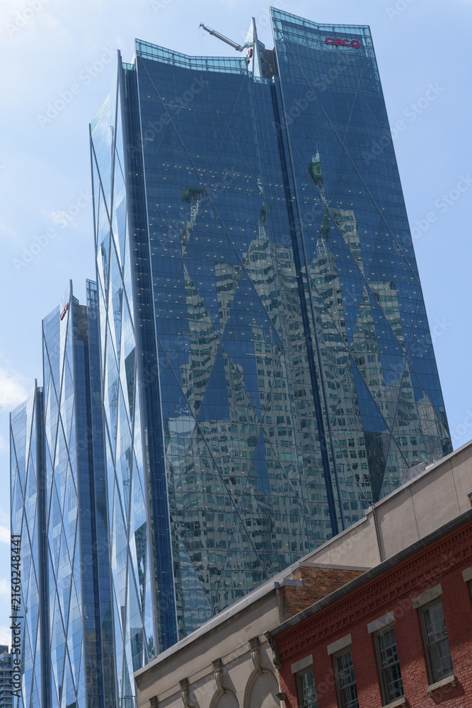 Fototapeta premium reflection of Brookfield Place on the diamond patterned windows of CIBC Square, designed by WilkinsonEyre, located at 81 and 141 Bay St, Toronto (headquarters of Canadian Imperial Bank of Commerce, an