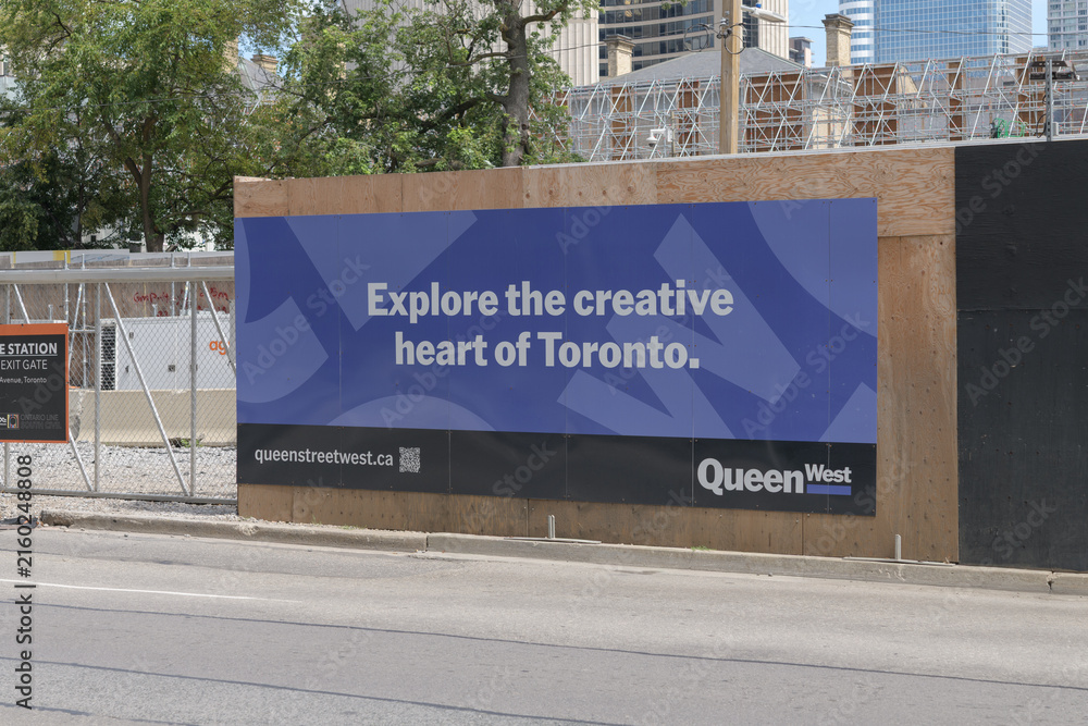 Fototapeta premium billboard on hoarding - Queen Street West Business Improvement Area (BIA) promoting the creative heart of Toronto
