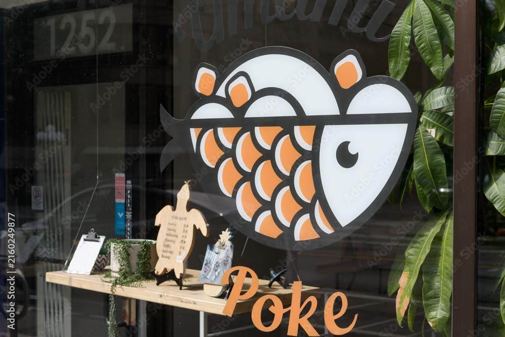 Fototapeta premium exterior building facade and vinyl window sign of Umami Poke, a Hawaiian restaurant, located 1252 Yonge St inside Summerhill Gardens, Toronto