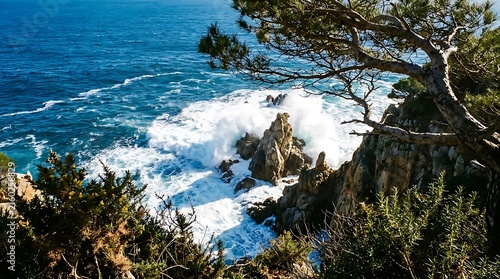 Ocean waves crashing against rocky cliffs on a sunny Mediterranean coastline