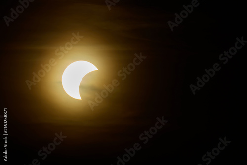 Принти на полотні Solar eclipse over the landscape, showing dark lunar silhouette gliding across t