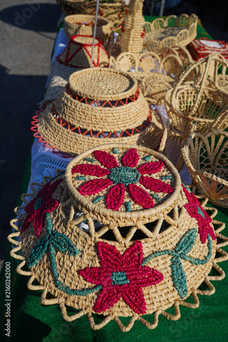 Фотография Collection of traditional handcrafted straw baskets and covers decorated with colorful woven floral designs