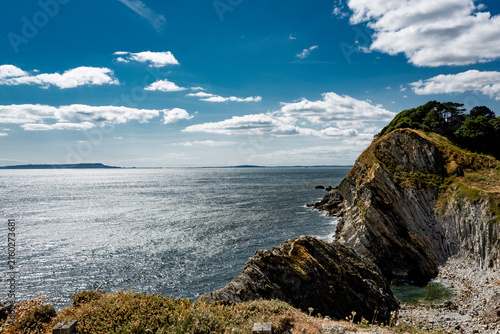 Photography Rocky headland and calm sea beneath a dramatic summer sky on the Jurassic coast