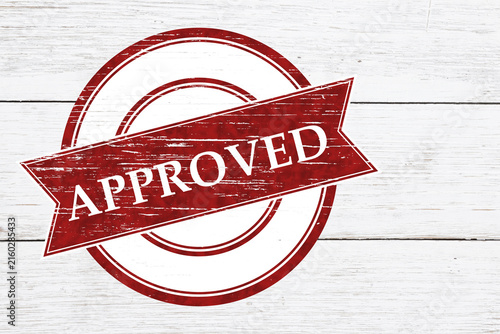 Red distressed Approved stamp on weathered wood for passing quality control