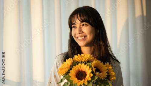 Joyful young woman holding sunflowers against a soft warm white background radiating positivity and warmth.