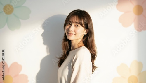 A young woman enjoying the golden hour sunlight with a warm smile under soft floral patterns in the background