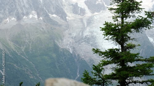 Brevent cable car cabin moving against Glacier des Bossons background in Chamonix Mont Blanc valley, famous alpine cableway public transport in French Alps mountain landscape during summer travel