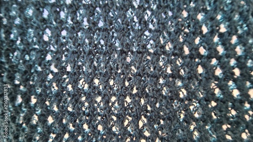 Macro texture of blue crochet mesh background with selective focus and bokeh.This creative handmade geometric yarn structure is suitable for summer holiday resort design backdrop.