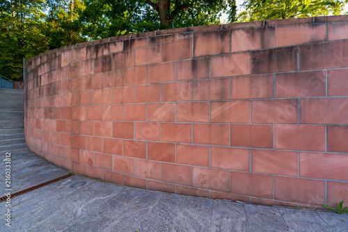 Obraz na płótnie Hohe helle rote Sandsteinmauer am Weg und am Hang mit Fußweg, Geländeausgleich