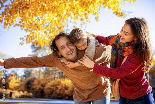 Bild auf Leinwand Father giving son a piggyback ride in autumn park