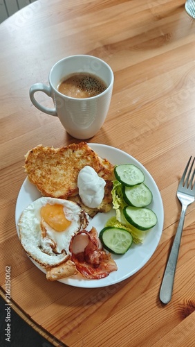 Fotografie Breakfast plate featuring fried egg, bacon, poached egg, cucumber slices, lettuc