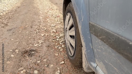 Car tire moving on gravel road, in gravel road with rocks and dirt, with car tire, gravel road, from a close-up of the car tire and perspective, with brown, gray accents.