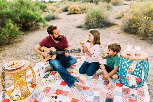 Father and Children having a Picnic and Playing Guitar