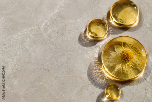 Floating golden oil droplets creating refractive lenses on clear water
