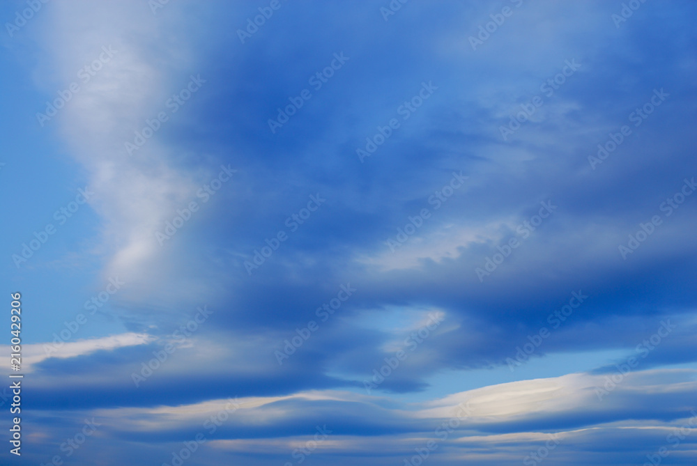 Obraz premium Scenic view of a vibrant blue sky filled with unique altocumulus lenticularis and stratified cloud formations creating a dramatic and textured atmosphere.