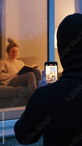 Stalker Secretly Filming Unsuspecting Woman Through Window at Home STALKING AND PURSUIT CONCEPT