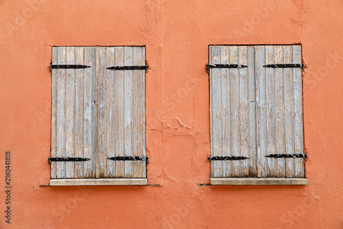 Vintage wooden window on a weathered plaster wall of an historic house