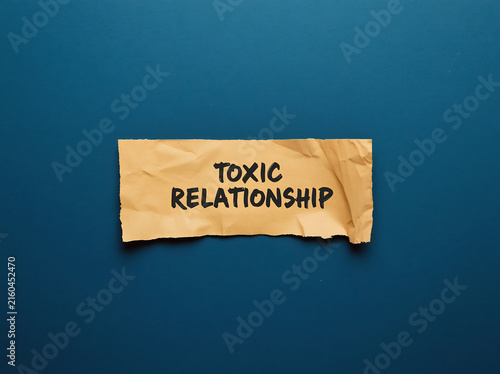 Toxic relationship concept with crumpled paper label. Emotional abuse awareness tag on torn kraft texture for mental health campaigns.