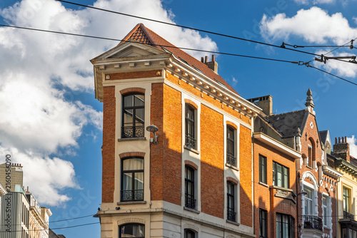 City of Brussels in Belgium, Europe. Classic European Architecture: A Beautiful Brick Building Against a Bright Blue Sky with White Clouds