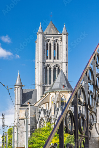 Ghent town in Belgium, Europe. St. Nicholas Church Against Clear Blue Sky with Detailed Architectural Features and Ornate Fence Foreground