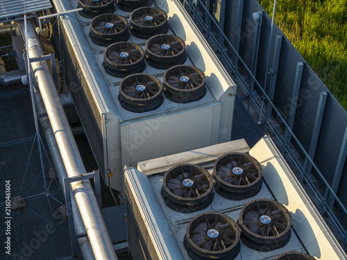 Aerial view of the industrial cooling system for an AI data center, featuring large ventilation fans and metal piping on a rooftop in Poland.