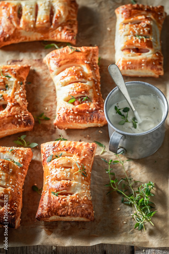 Unique sausage in puff pastry with tatar sauce and herbs.