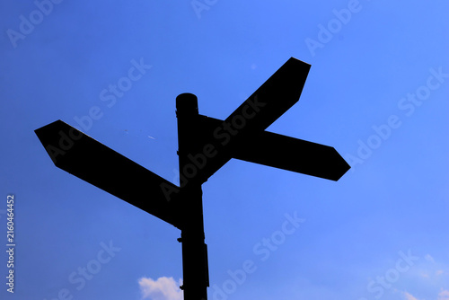 Silhouette of a multi-direction signpost symbolizing choice and orientation
