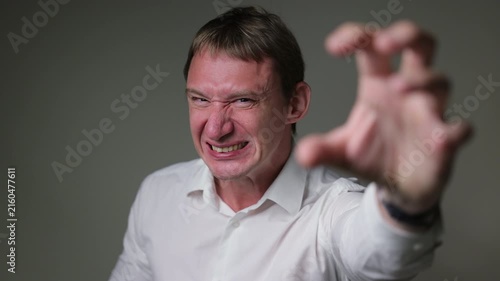 Businessman in a suit looking at the camera with a angry and disappointed facial expression. Studio portrait isolated on a white background, suitable for business, stress andal concepts.