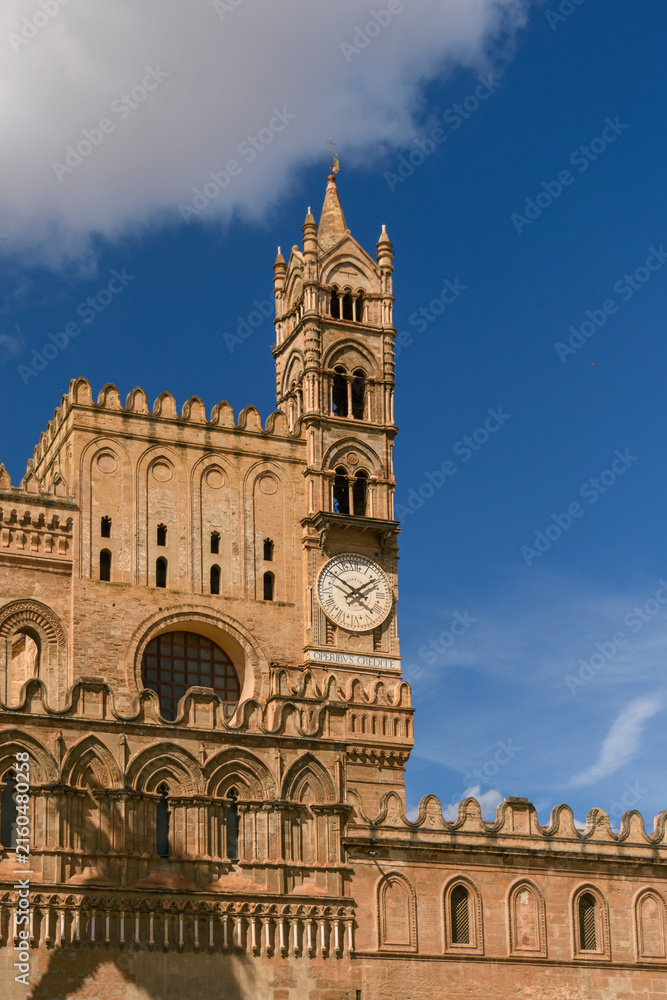 Obraz premium Imponente torre del reloj de estilo gótico-normando en la fachada de la gran catedral de Palermo en un día soleado.