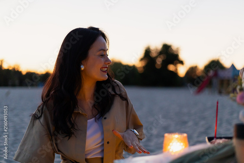 Foto Woman enjoying a warm sunset on a sandy beach with a candlelit glow